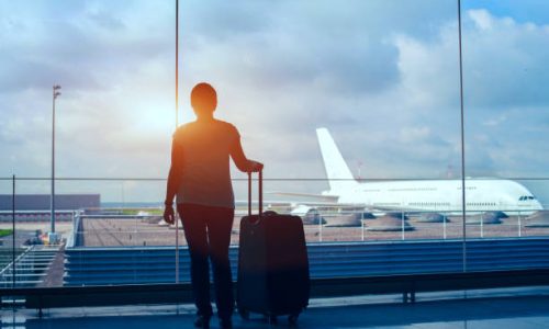 silhouette of woman passenger waiting in airport with suitcase, international travel by plane, tourism and immigration